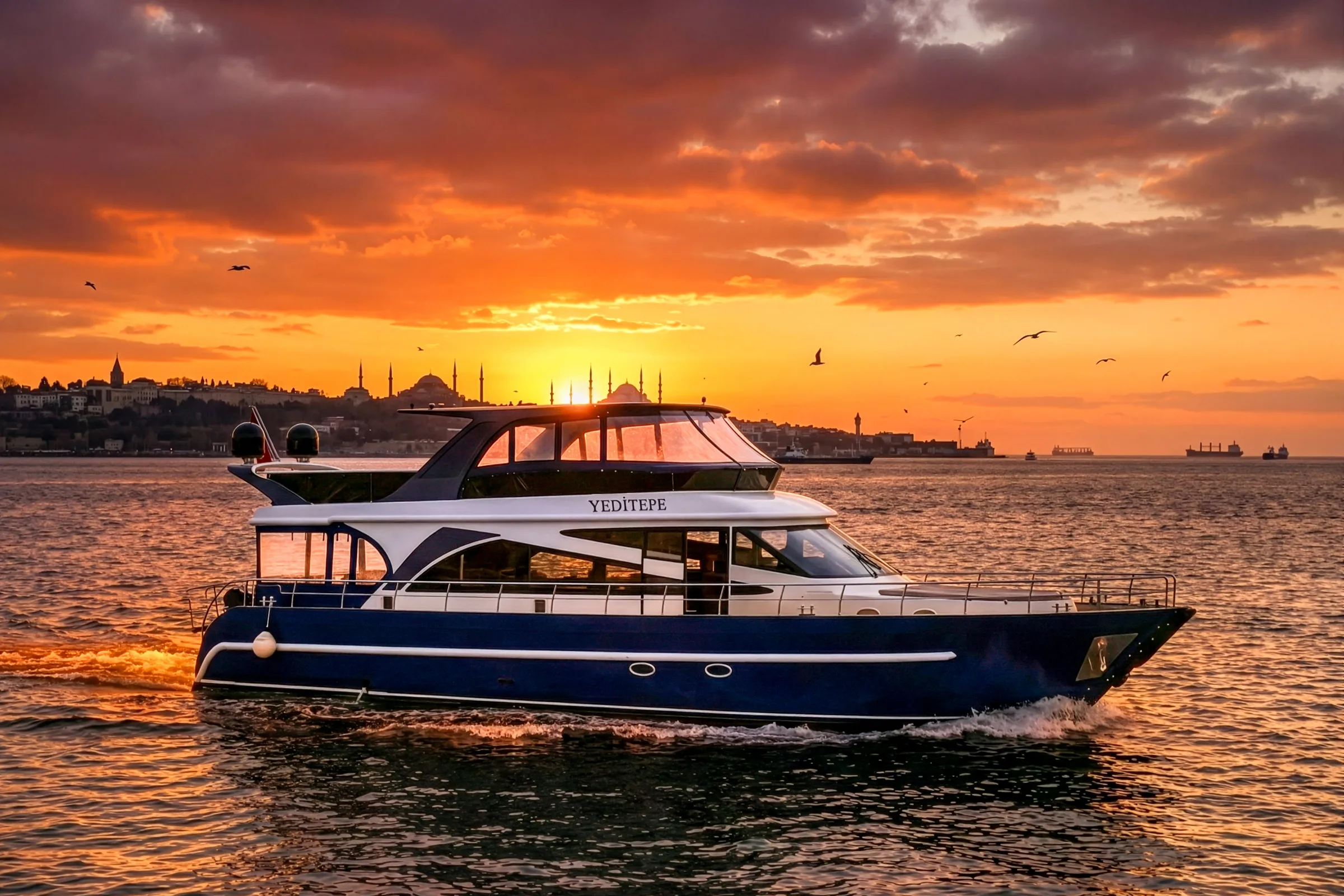 Yeditepe yacht at sunset on the Bosphorus, Istanbul old city skyline behind